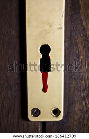 Drop of blood leaking out of keyhole on a old messy lock