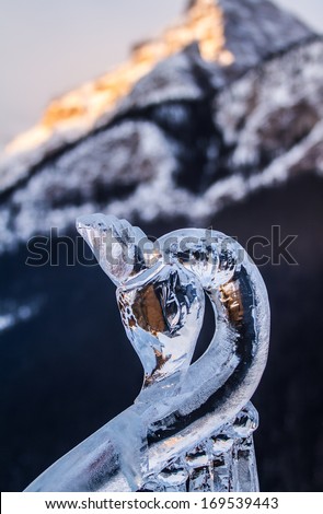 Ice carving of a swan with mountains in the background