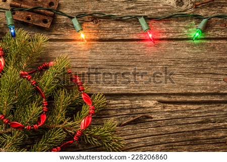 Christmas Lights on Old Rustic Wood Background and Pine Tree & red Garland