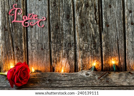 Red Rose with the Word Love on Rustic Old Barn Wood with Lights
