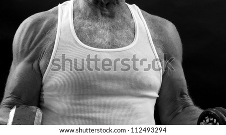 senior muscle: torso, arms, and shoulders of 65-year-old lifting weights