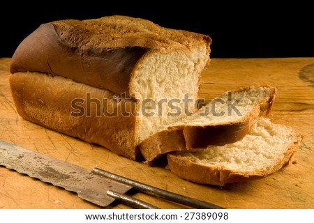 freshly baked white bread with old bread knife