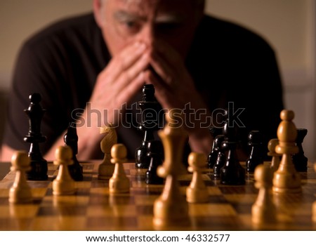Man studying chess board, selective focus