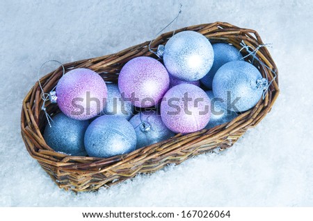Basket with Christmas balls in blue snow