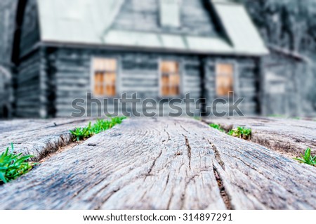Rustic wooden planks with blurred old wooden house background