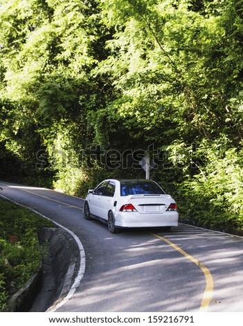 Hilly asphalt road with white car