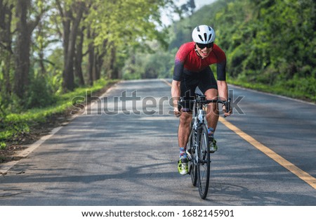 Image, Stock Photo healthy man riding a bicycle on a mountain road in a sunny day