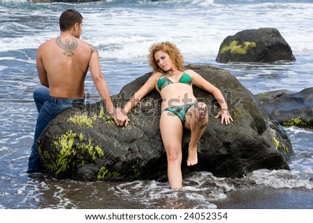 boy and girl lying on her back on the rocks