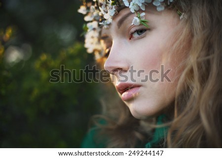 Mysterious beautiful girl with flowers in her hair. Queen blooming gardens. Fields of flowers. Eyes closed. Sleeping beauty