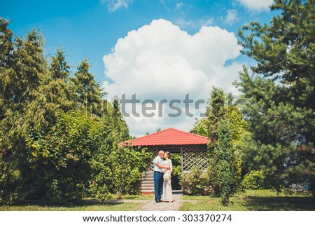 Bride and groom hugging each other gently during a walk in the summer park