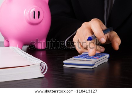 Business woman in suit calculating account on dark table.
