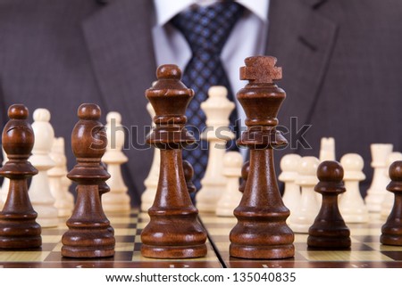 Businessman waiting for playing and chess pieces on chess table.