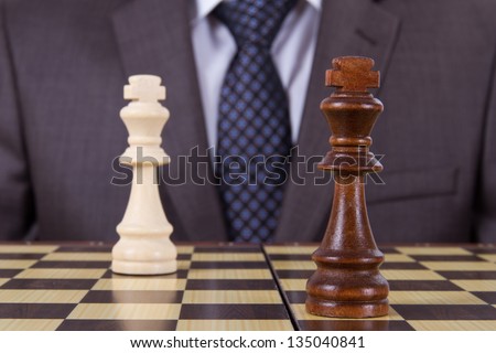 Businessman get drawn on chess game, two kings on chess board.