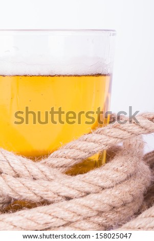 Full of beer glass and rope, isolated on white background.