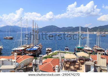 MUGLA, TURKEY - JUNE 1, 2015 : Top view of Marmaris Marina among mountains with sailing boats and yatches anchored, on blue sky background.