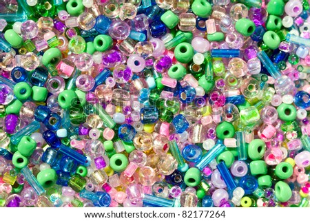 A colorful background of plastic beads in various colors and shapes.