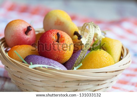 Fruit shaped candies in macro image of marzipan sweets in a basket, close-up