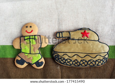Homemade Gingerbread man in protective khaki uniforms and the tank on Defender of the Fatherland Day