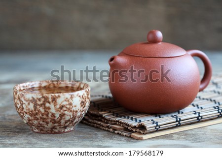 Traditional chinese tea ceremony accessories: tea pot, cup on the wooden table, selective focus on tea pot