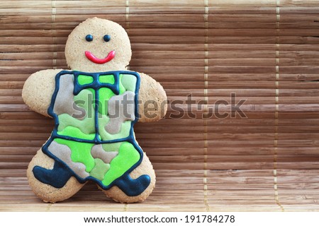 Homemade Gingerbread men in protective khaki uniforms on Defender of the Fatherland Day, close up, place for text