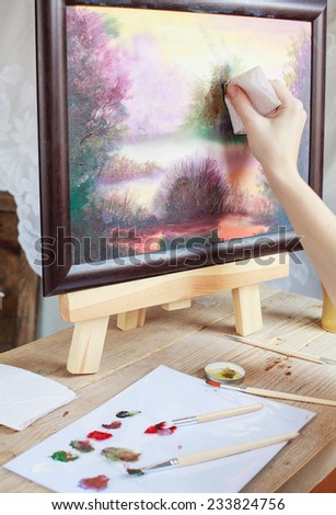 The artist paints a picture of the landscape using oil paints mounted on an easel. Selective focus