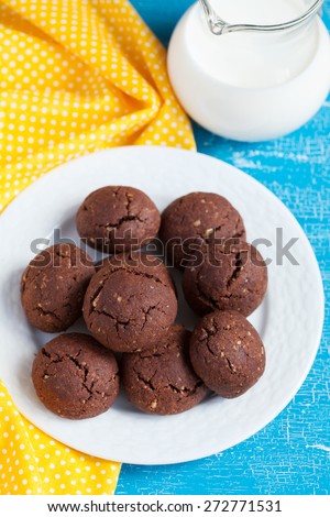 Italian chocolate cookies with walnuts and a cup of coffee on a blue wooden table, rustic style, selective focus