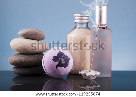 multiple items from spa beside a lit incense stick