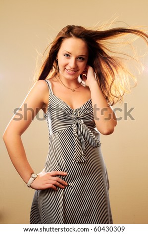 Pretty woman in stylish dress with fluttering hair