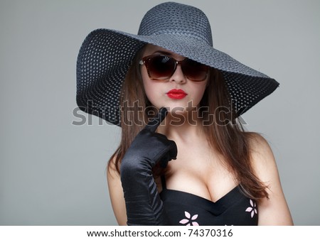Young woman in black hat and sunglasses .Focused on glove