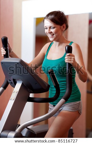 Young women in gym on stepper machine