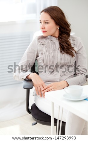 Beautiful business woman sitting at office, window outside background