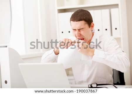 angry businessman with document in office