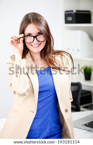woman wearing glasses posing in office dress