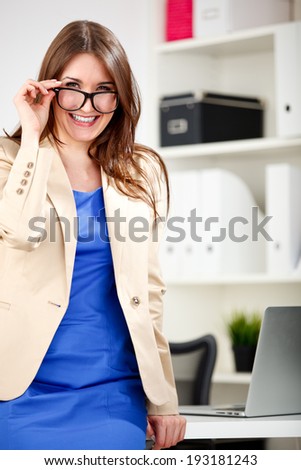 woman wearing glasses posing in office dress