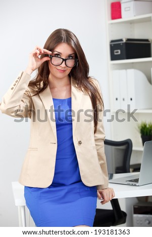 woman standing in blue dress and jacket at office
