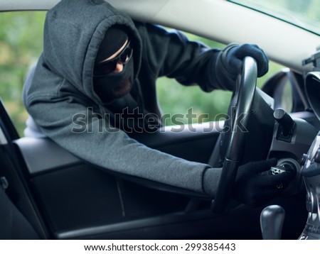 Burglar wearing mask balaclava stealing car key