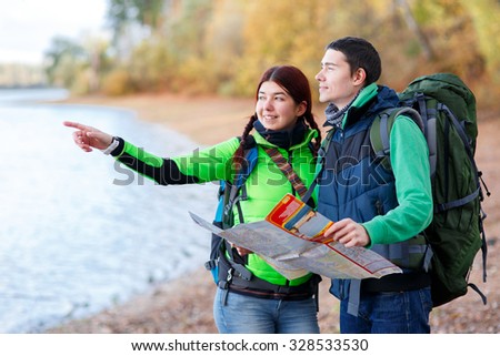 Pretty young woman on hiking trip with man in countryside