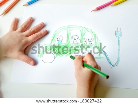 Close-up of childs hands drawing a green electric zero emission car