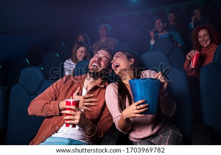 Group of cheerful people laughing while watching movie in cinema. Imagine de stoc © 