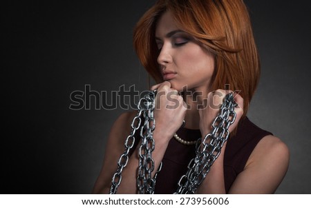 Portrait of a elegantly dressed young women chained.