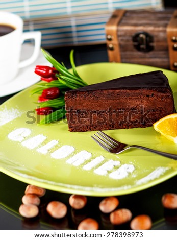 A slice of rich dark chocolate cake with word calories written on the plate.