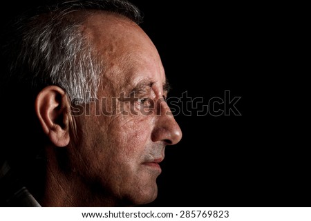 Profile of a senior man on black background, Side view