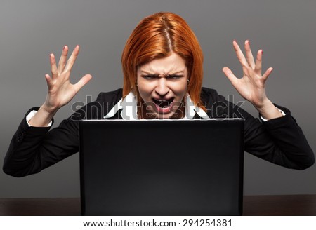 Angry Businesswoman screams at the laptop