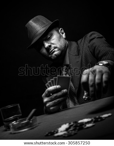 Male gambler playing poker and smokes a cigar, Black and white