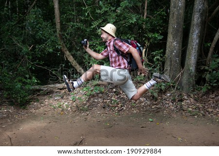 funny tourist with a camera running in the woods - Stock Image - Everypixel