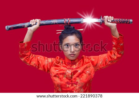 Asian woman holding a samurai sword over his head