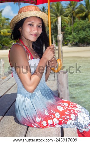 young woman in dress sitting by the sea