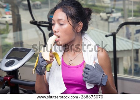 woman at the gym eating a banana