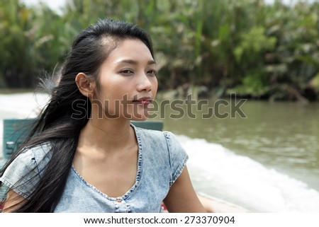 Young woman sitting in a taxi boat on canal - way to the monastery Wat Khun Samut