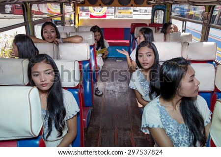 Many identical passenger clones sitting inside older bus